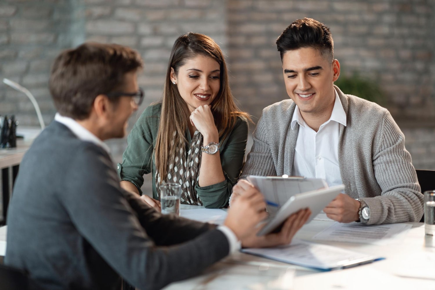 joven-pareja-feliz-consultando-gerente-banco-reunion-oficina-min